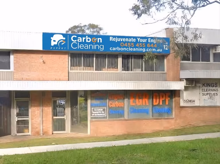 Expert Carbon Cleaning signage on the building seen from Vardys Road, Kings Park, with EGR and DPF cleaning graphics in the windows