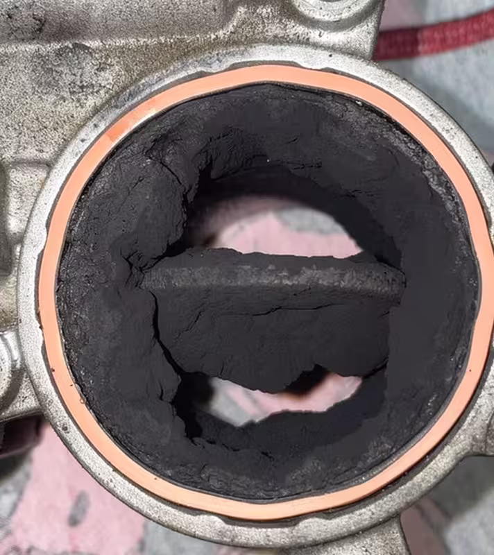 Throttle body off the engine, the bore packed solid with dry carbon and the butterfly plate buried