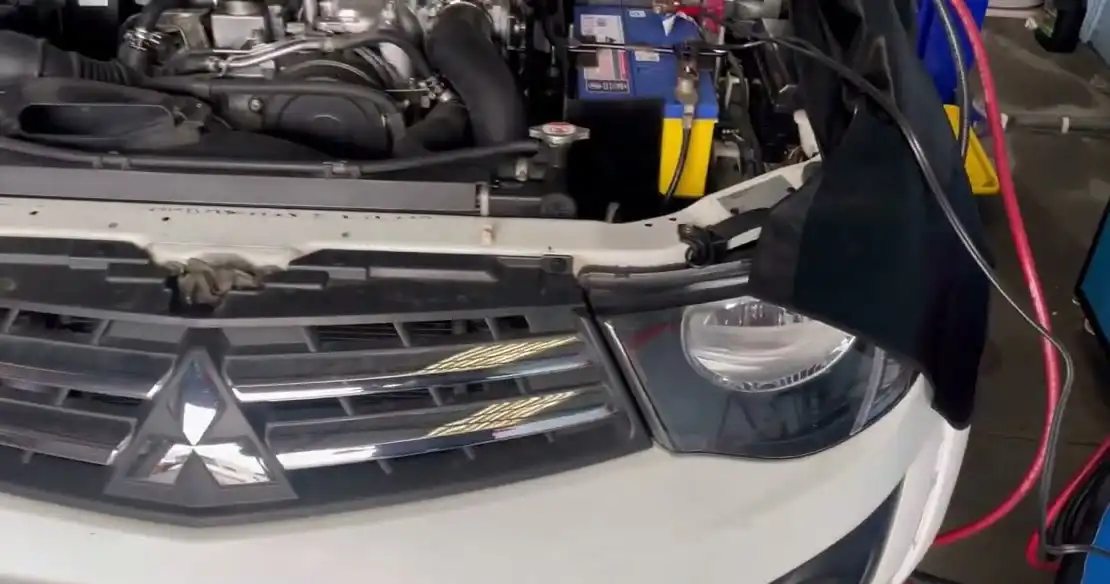 Mitsubishi Triton at the Kings Park workshop with the fuel system cleaning machine's hoses connected under the bonnet
